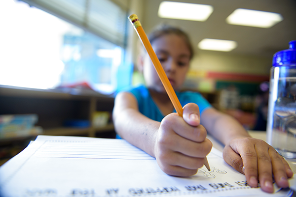 Child writing with a pencil